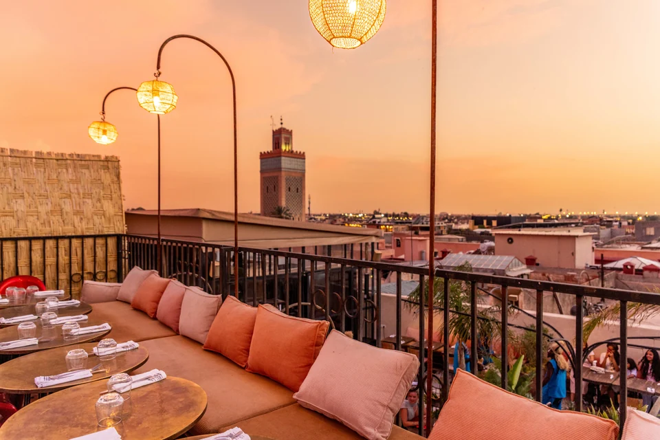 Faroles y asientos de la terraza con vistas a la Koutoubia al atardecer