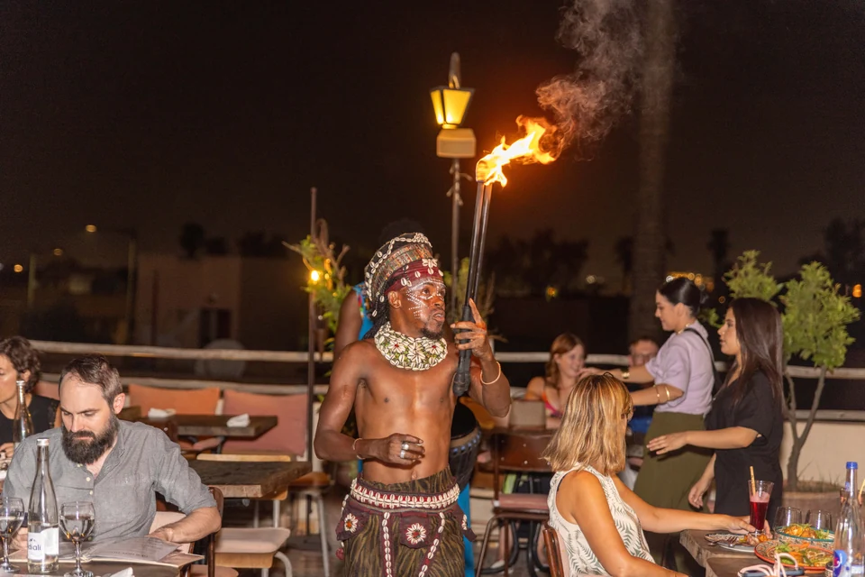 Artista ofreciendo un espectáculo de fuego junto a las mesas de Coco Rooftop